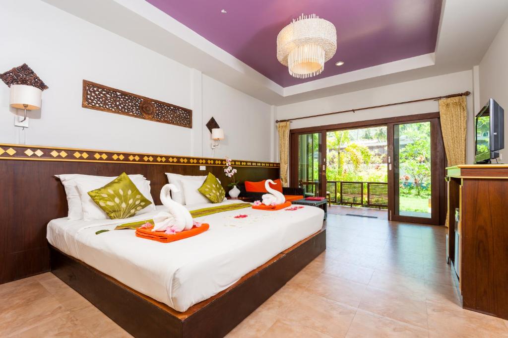 a bedroom with a bed with two swans on it at Simple Life Resort Koh Tao in Koh Tao