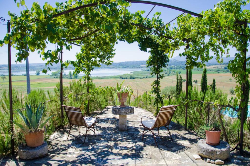 a patio with chairs and a pergola with a view at Agriturismo Poggio Antico in Binami