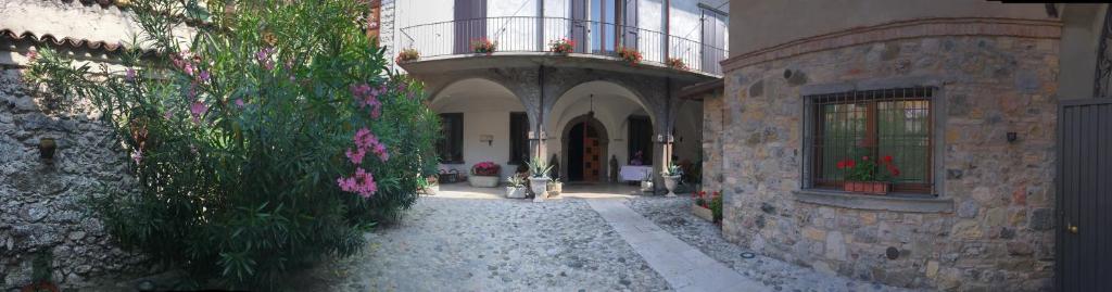 ein Gebäude mit einem Balkon mit Blumen darauf in der Unterkunft B&B Al Caseificio in Barghe