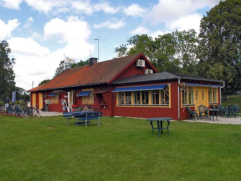 un edificio rojo con una mesa de picnic delante de él en Wassbacken Vandrarhem, en Töreboda