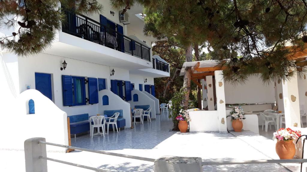 ein Gebäude mit blauen und weißen Wänden sowie Tischen und Stühlen in der Unterkunft Kocheilas Studios in Gialiskari