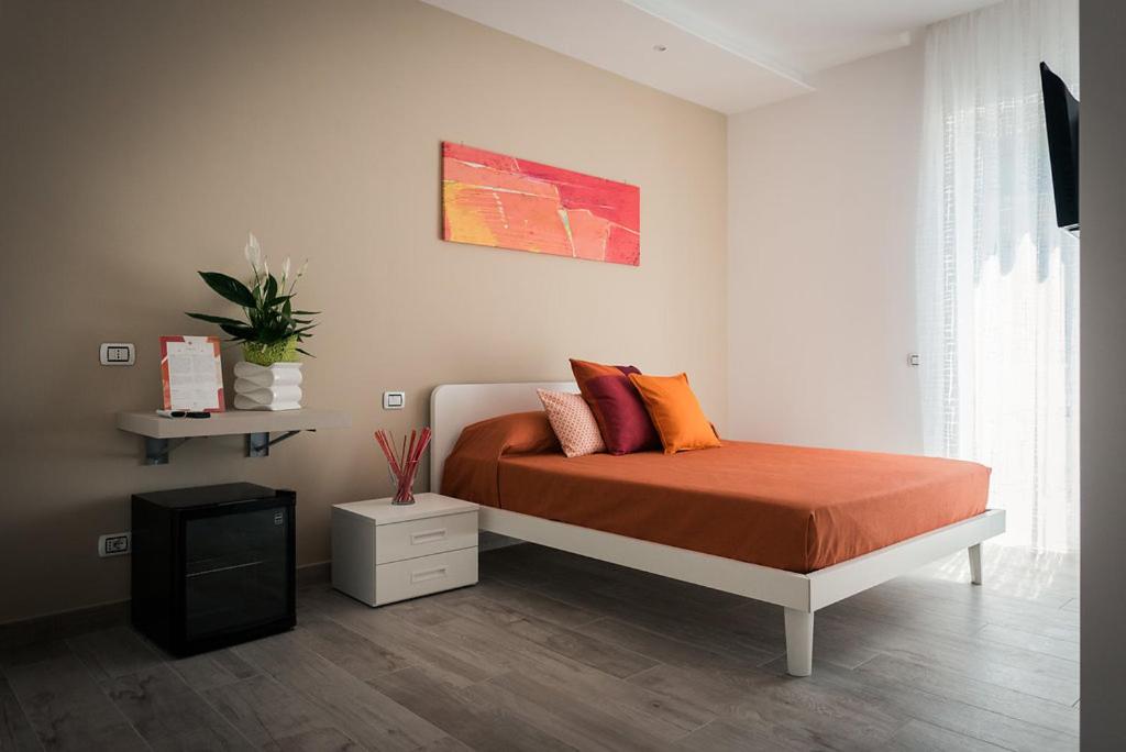 una camera da letto con un letto con cuscini arancioni sopra di L'Agrumeto a Procida