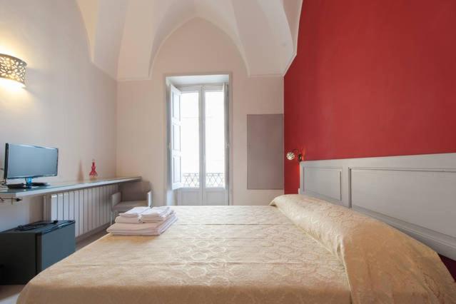ガラティーナにあるKaleidos Guest Houseの赤い壁のベッドルーム1室(大型ベッド1台付)