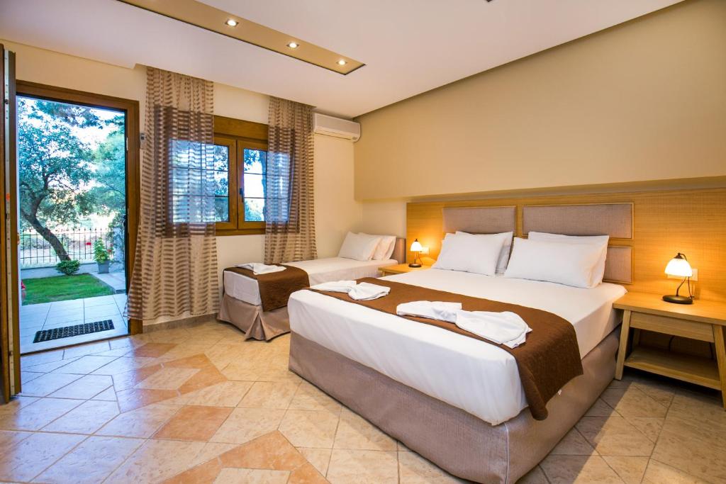 a bedroom with two beds and a large window at Villa Katerina in Potos