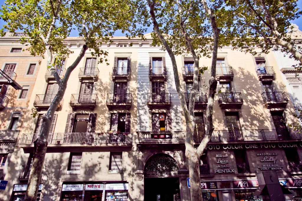 a large building with a tree in front of it at Ramblas Apartments in Barcelona