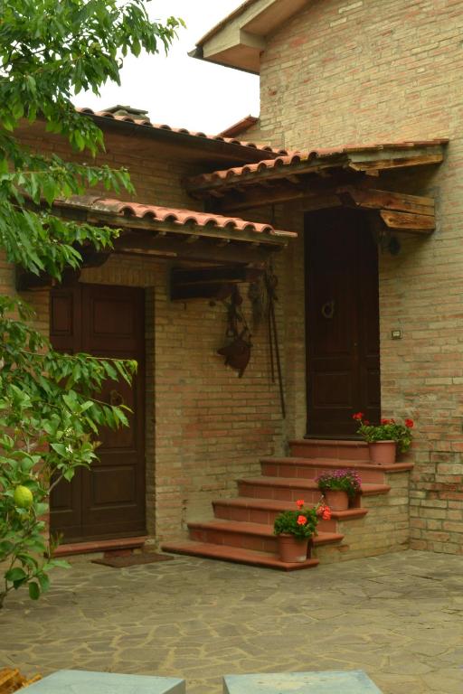 a brick house with stairs and a door at Appartamenti La Miniera in Castelnuovo Berardenga