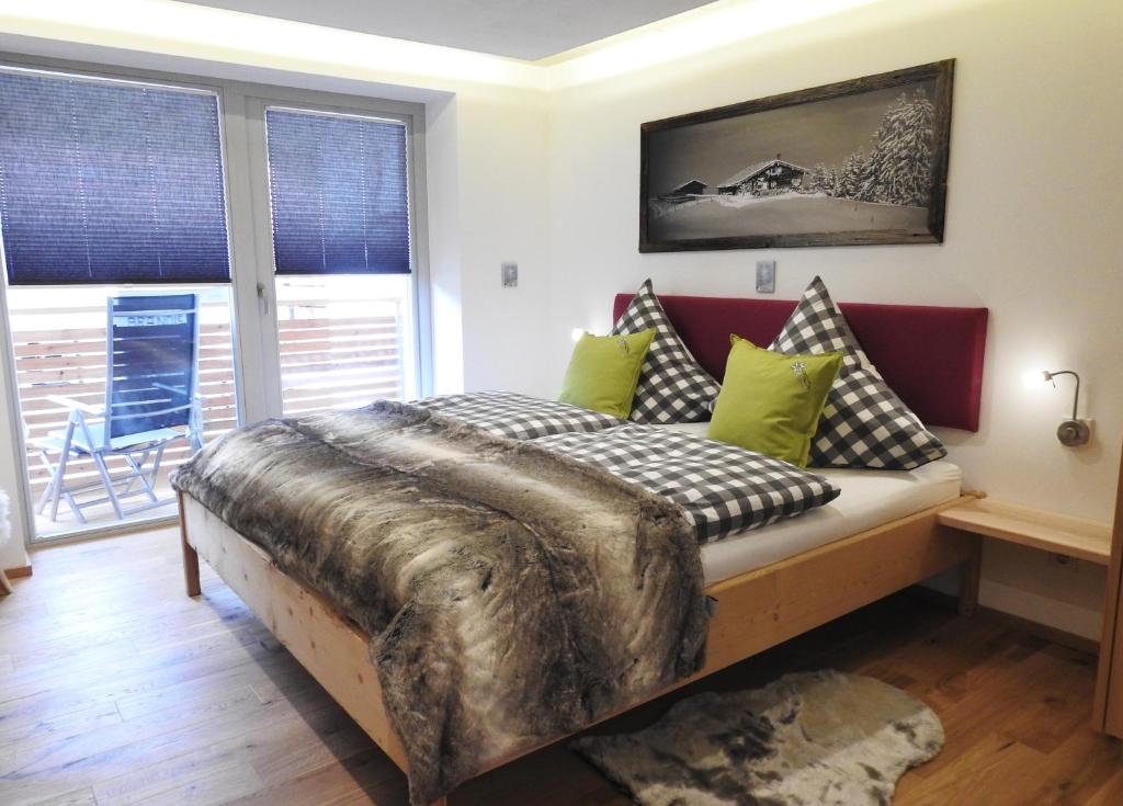 um quarto com uma cama com almofadas em Leos Alpenblume inklusive Sommer Bergbahnticket em Oberstdorf