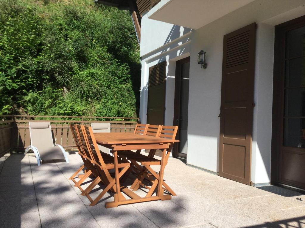 a wooden table and chairs on a patio at Au chalet des quatre saisons in Ax-les-Thermes
