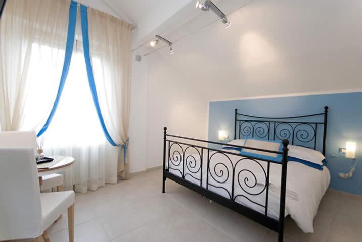 a bedroom with a bed and a desk and a window at Villa Cristina in Monterosso al Mare