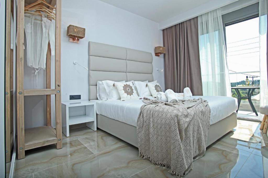 a bedroom with a large bed and a large window at Imagine Studios in Paliouri
