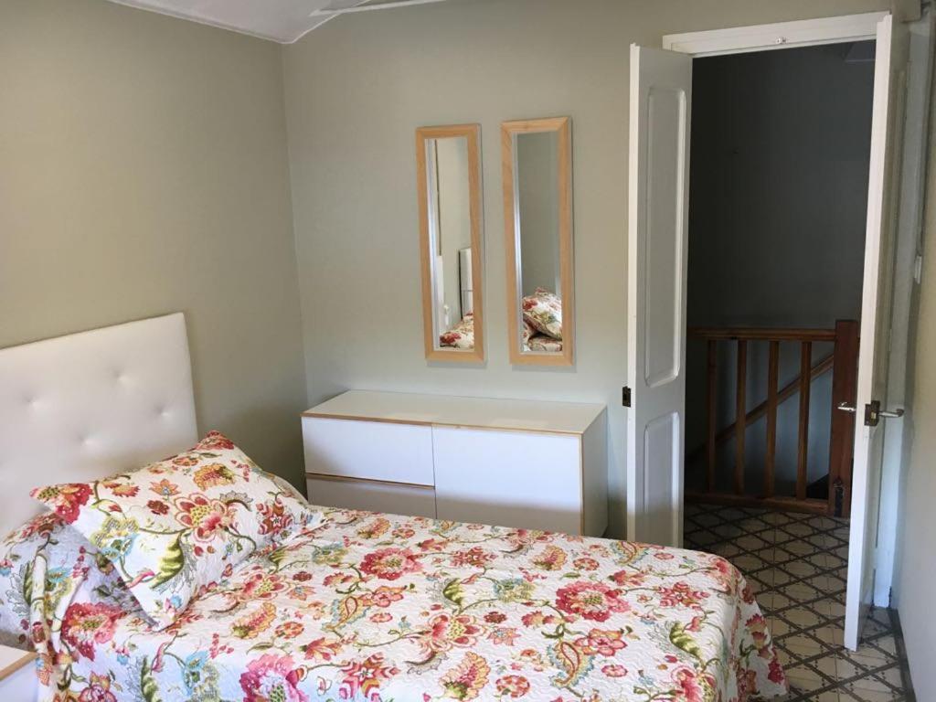 1 dormitorio con cama, tocador y espejo en LA FARMÀCIA en LʼAmetlla de Merola