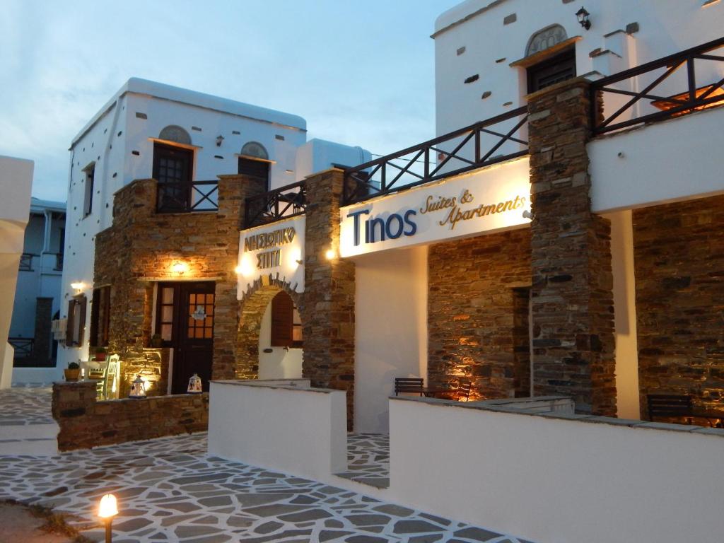 a building with a sign on the side of it at Tinos Suites & Apartments in Agios Ioannis