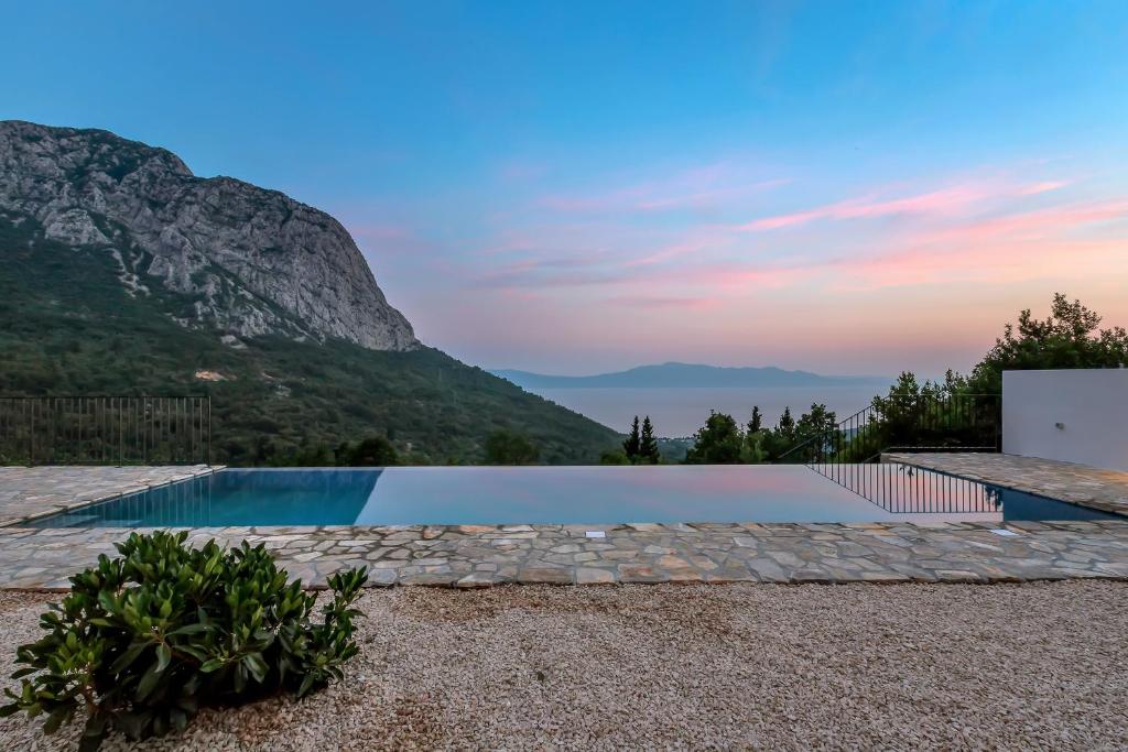 uma piscina com uma montanha ao fundo em Villa Mate em Zaostrog