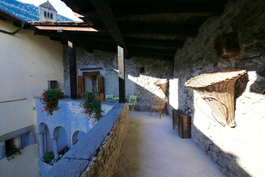 a hallway of a building with a basket on the wall at Il Granaio di Palazzo Guicciardi in Ponte in Valtellina