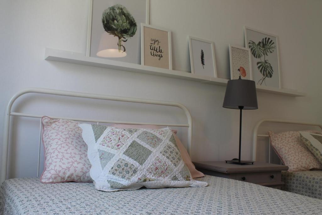 a bedroom with a bed with a pillow and shelves at Charming baixa in Lavradio