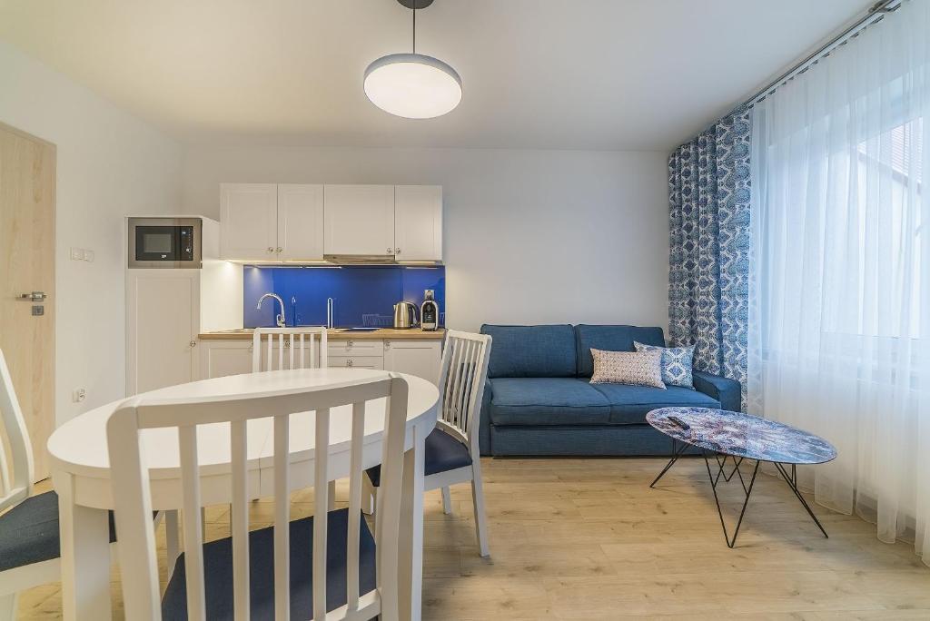 eine Küche und ein Wohnzimmer mit einem Tisch und einem Sofa in der Unterkunft Apartamenty Draga in Jastarnia