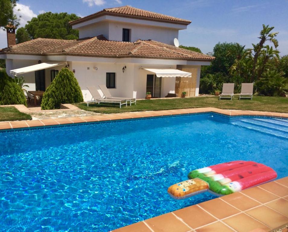 a swimming pool in front of a house at B&B Villa Pinos Málaga in Alhaurín de la Torre