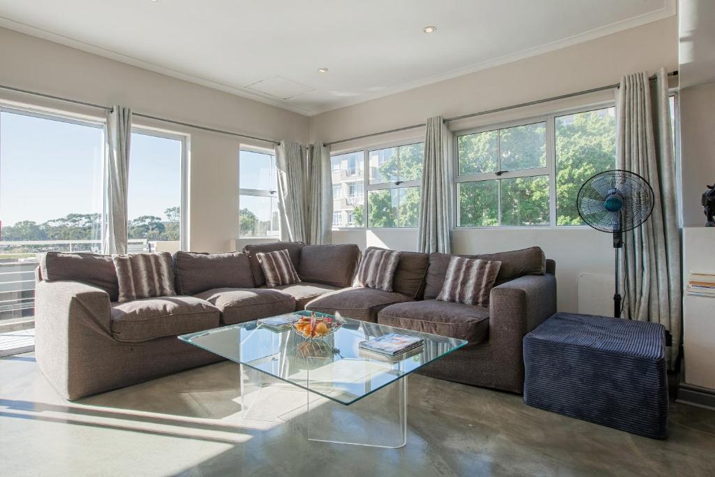 uma sala de estar com um sofá e uma mesa de vidro em York Mews 14 by CTHA em Cidade do Cabo