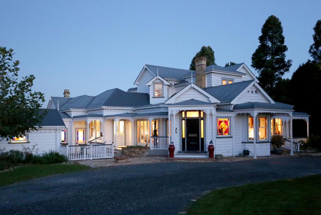 a white house with a driveway at Maungakawa Villa in Cambridge