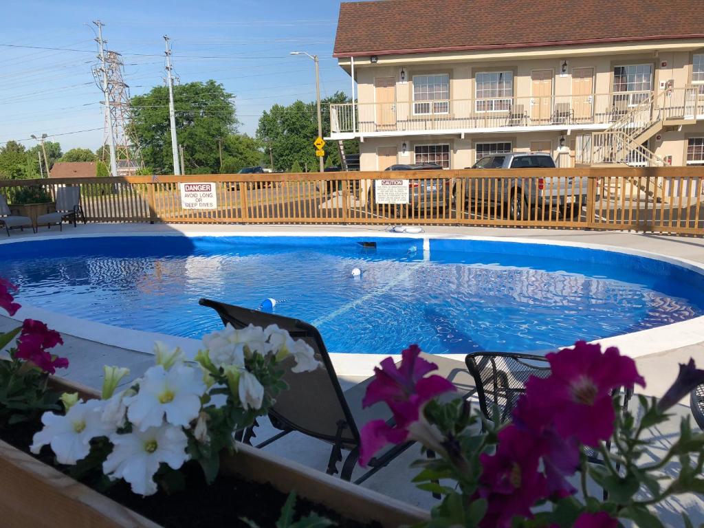 una piscina frente a un edificio con flores en Falls Lodge by the Falls (Formerly Knights Inn), en Niagara Falls