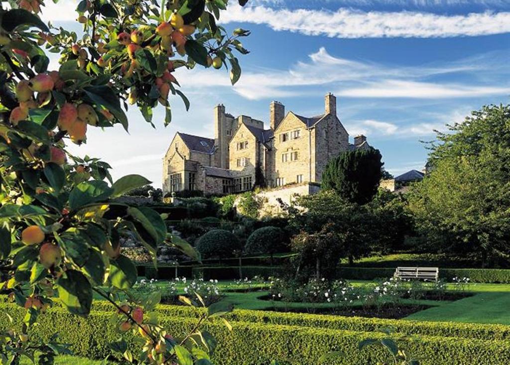 a large house sitting on top of a lush green yard at Bodysgallen Hall and Spa in Llandudno