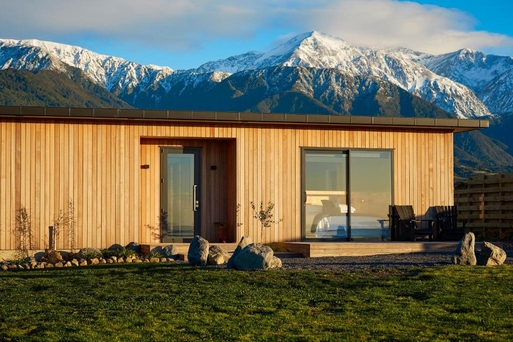 a wooden house with mountains in the background at Glenburn Coastal Retreat in Kaikoura