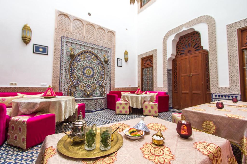 un comedor con mesas rosas y sillas rosas en Dar Bab Guissa, en Fez