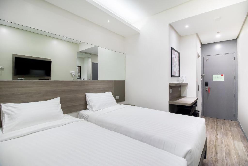 a hotel room with two beds and a tv at Red Planet Manila Binondo in Manila