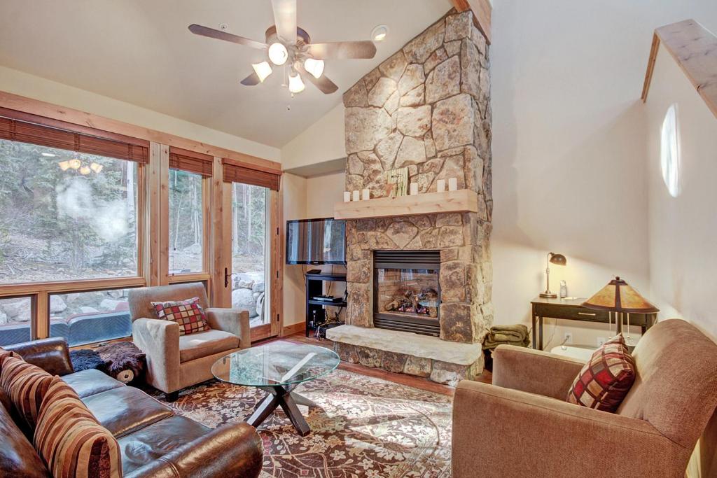 a living room with a stone fireplace and furniture at 6509 Settlers Creek Townhomes in Keystone
