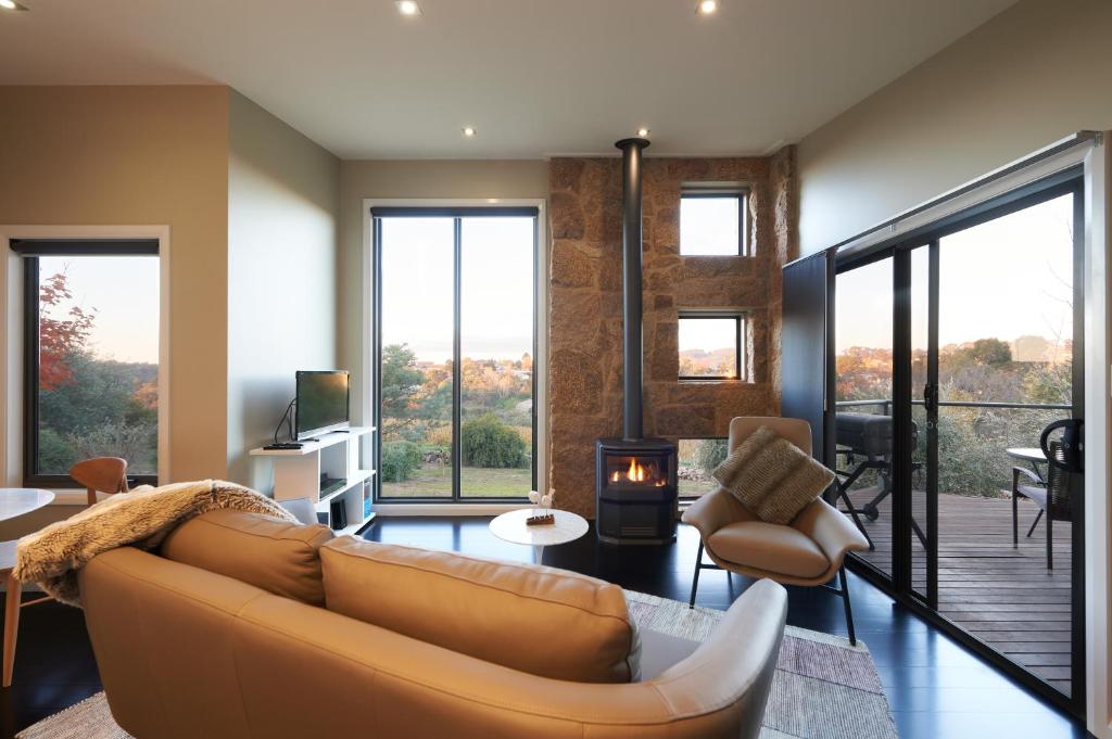 a living room with a couch and a fireplace at StoneTryst Spa Villas in Beechworth