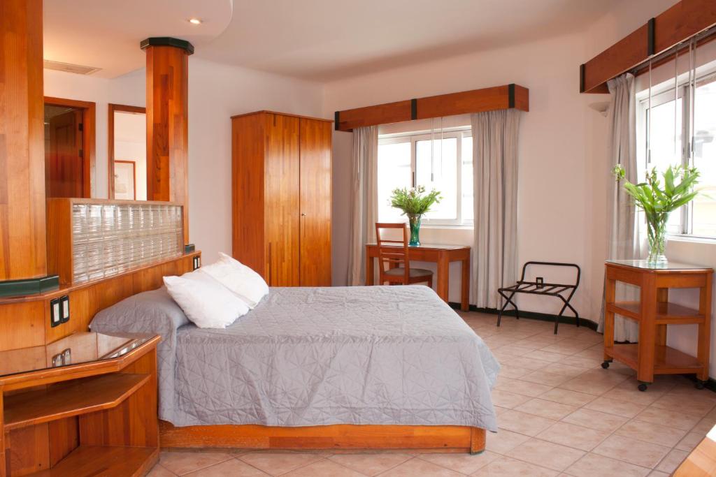 a bedroom with a bed and two windows at Casa Tobalá in Oaxaca City