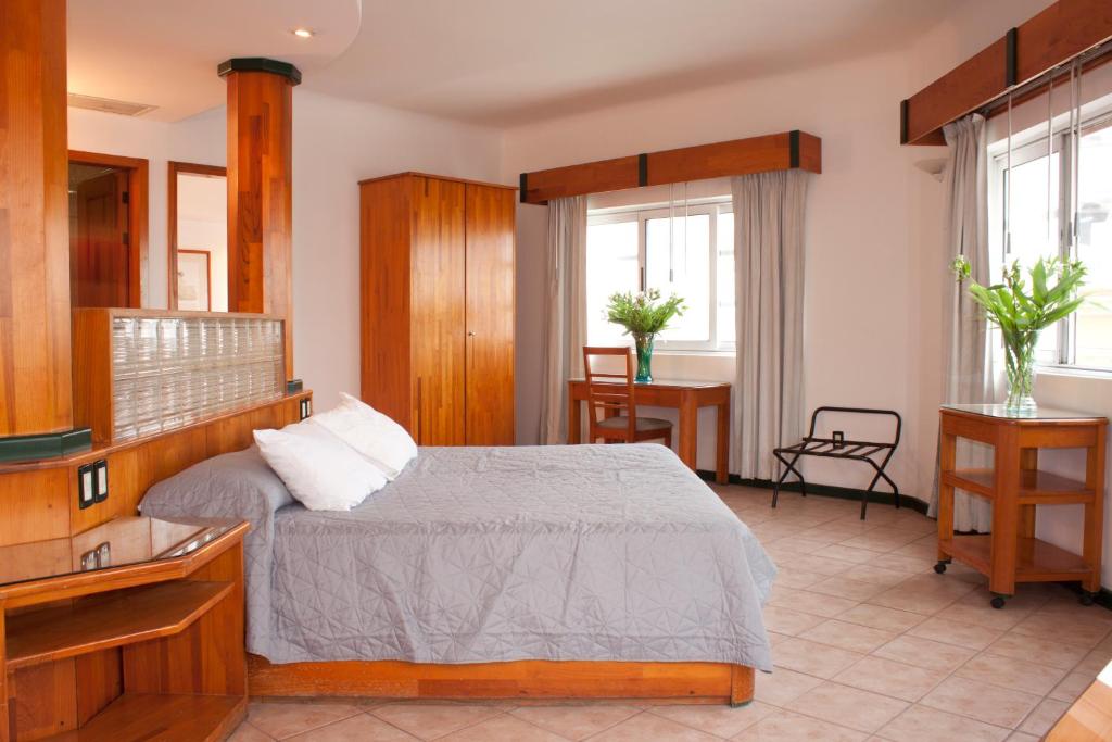 a hotel room with a bed, table and a window at Casa Tobalá in Oaxaca City