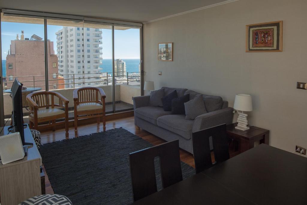 sala de estar con sofá y vistas a la ciudad en Departamento Viña Del Mar 4 Norte, en Viña del Mar