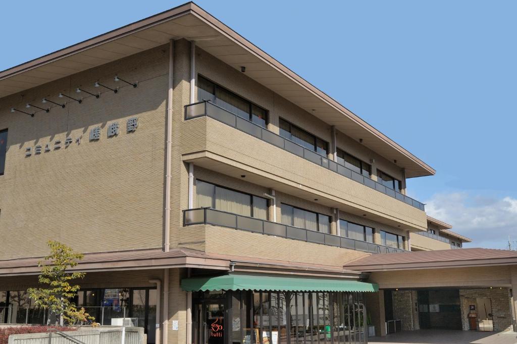 ein großes Gebäude mit einem Balkon an der Seite in der Unterkunft Hotel Binario Saga Arashiyama in Kyoto