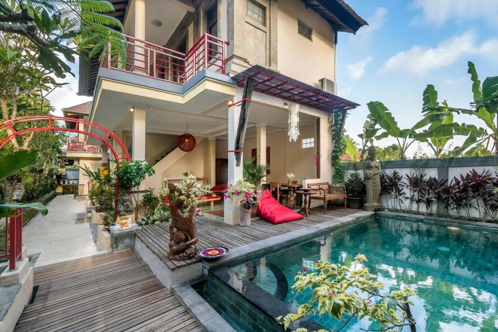 a house with a swimming pool in front of a house at Metteyya Healing House in Ubud