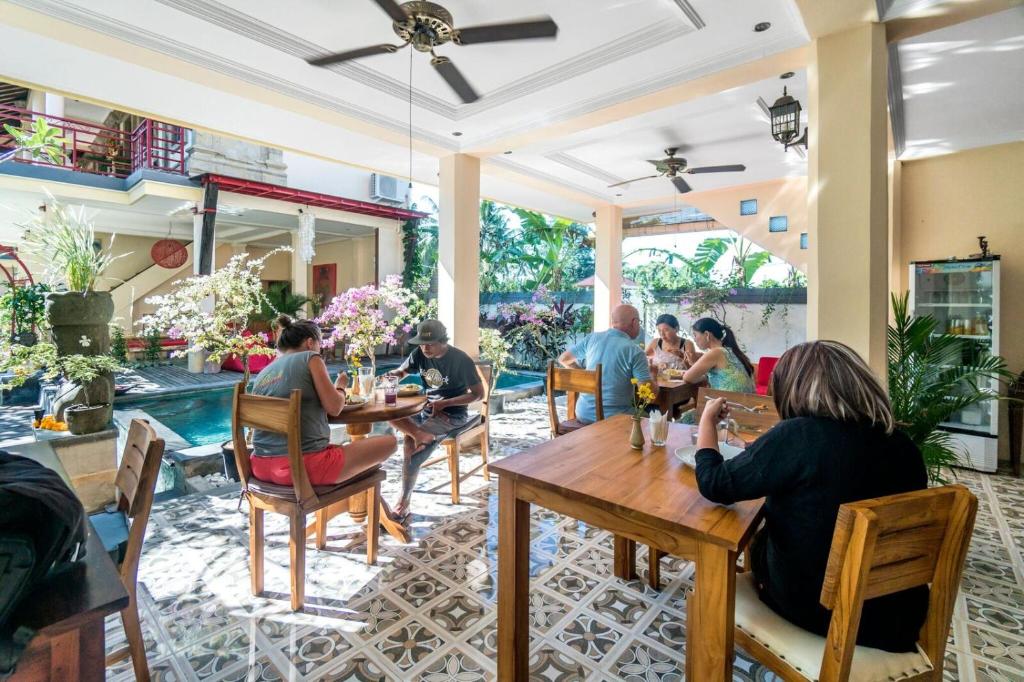 a group of people sitting at tables in a restaurant at Metteyya Healing House in Ubud