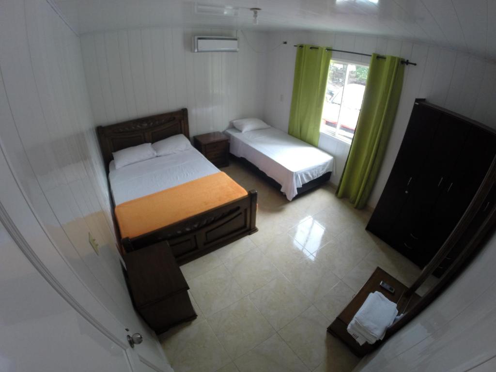 Habitación pequeña con 2 camas y TV de pantalla plana. en Zippy´s Sea View Apartments en San Andrés