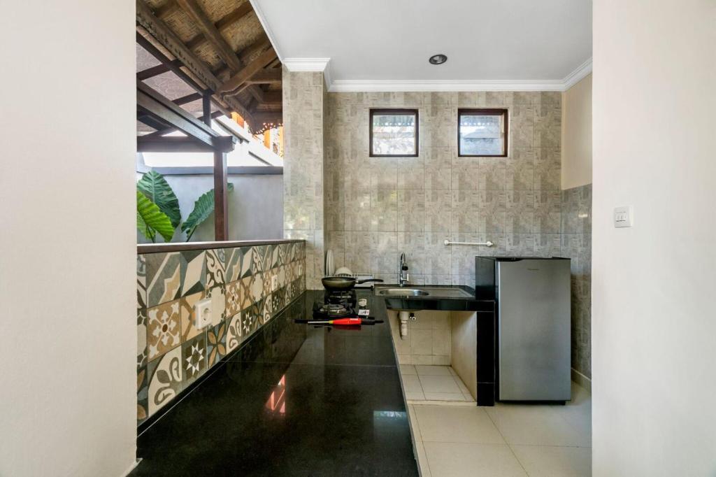 a kitchen with a black counter and a sink at Metteyya Healing House in Ubud