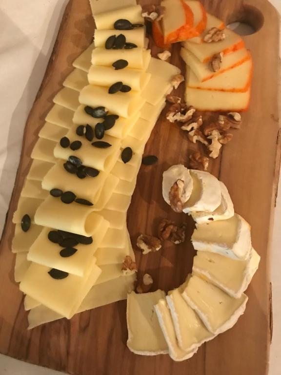 a wooden cutting board with different types of cheese at Remushof Jagschitz in Oslip