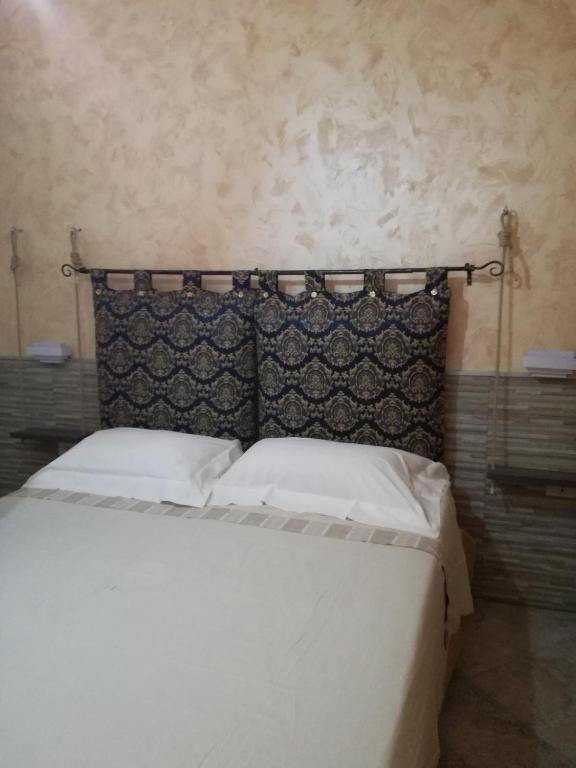 a bedroom with a white bed with a black headboard at Casa Solemare in Torre Lapillo