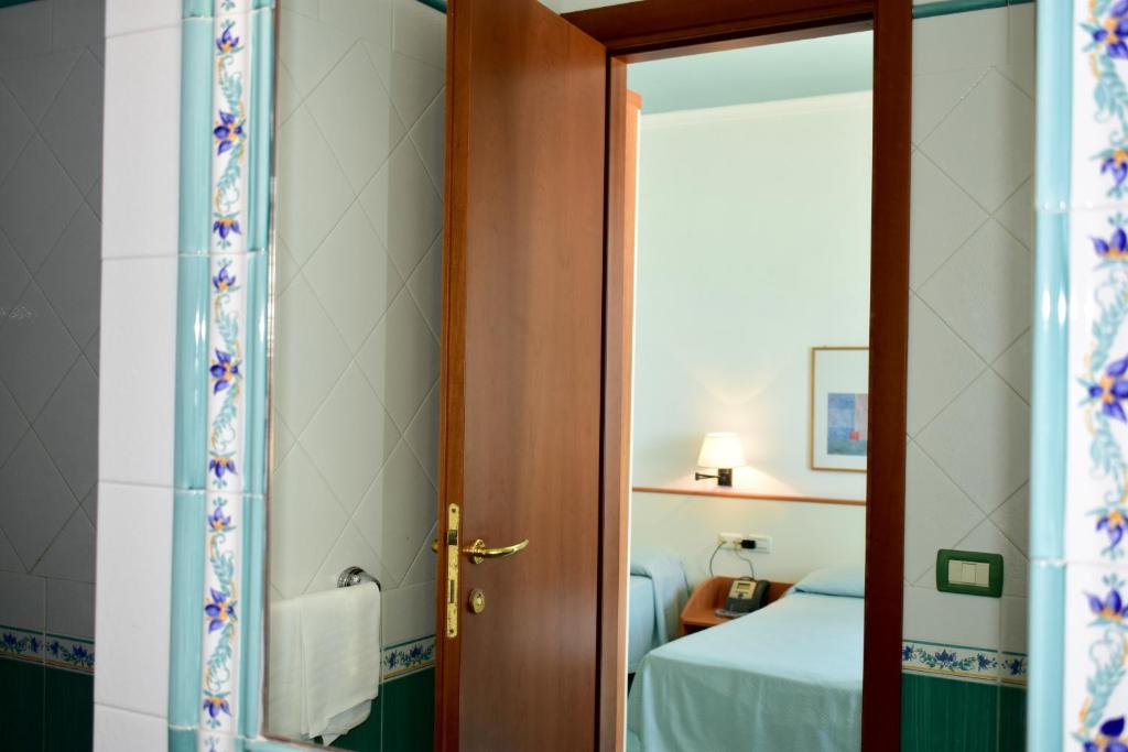 a door leading to a bedroom with a bed at Hotel Amyclae in Sperlonga