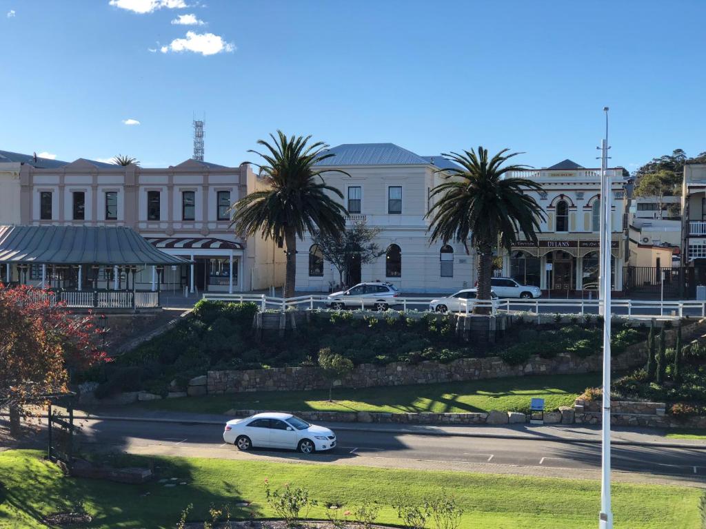 a car parked in a parking lot in front of a building at Albany Foreshore Guest House in Albany