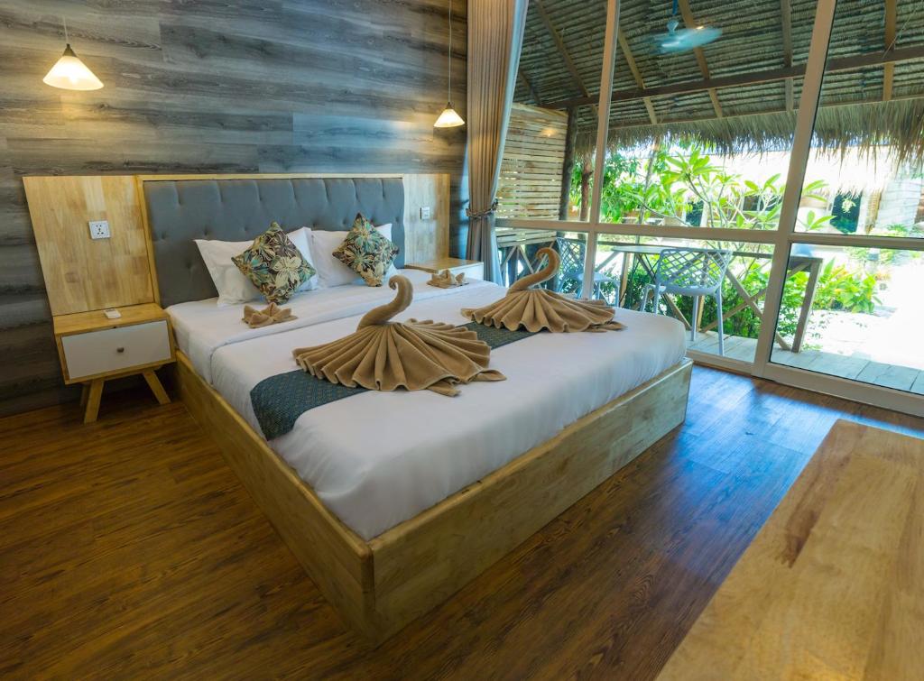 a bedroom with a bed with two swans on it at Sara Resort in Koh Rong Sanloem