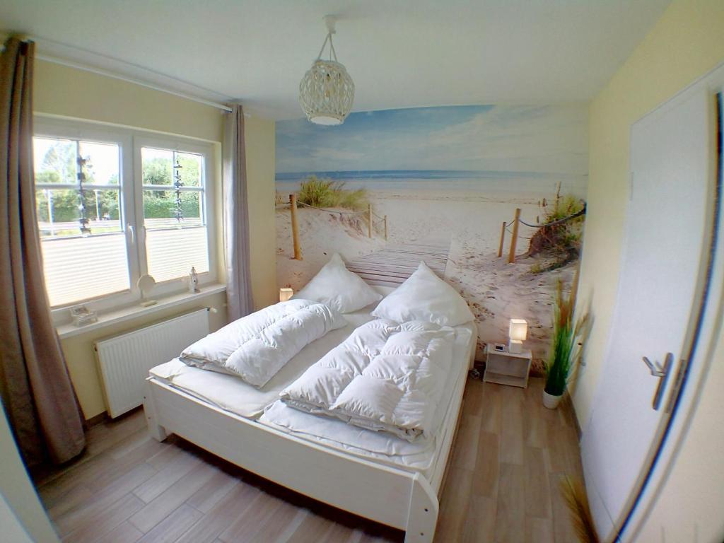 - une chambre avec un lit orné d'une peinture représentant une plage dans l'établissement Ferienwohnung Deichstr De Lorenzo, à Carolinensiel