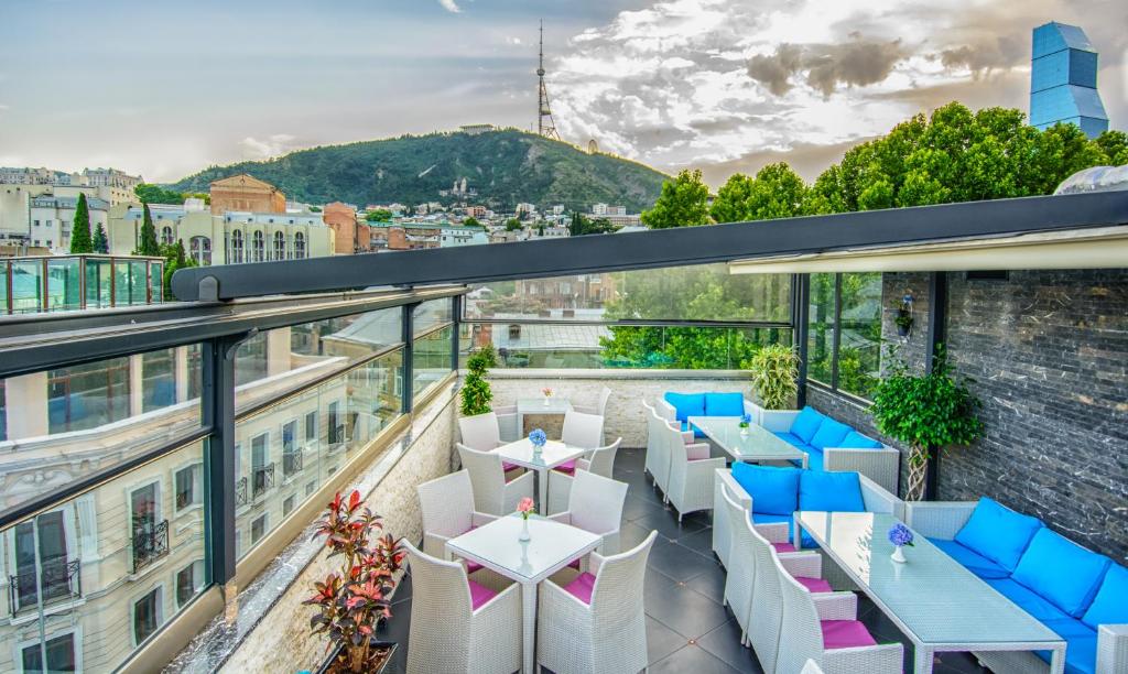 a balcony with tables and chairs on a building at River Side Hotel Tbilisi in Tbilisi City