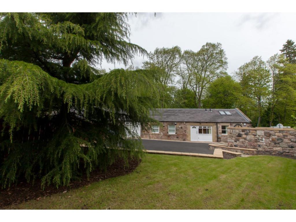 uma casa de tijolos com uma parede de pedra e um quintal em Historic Stone Built 4BR Cottage for 8 W/Parking em Edimburgo
