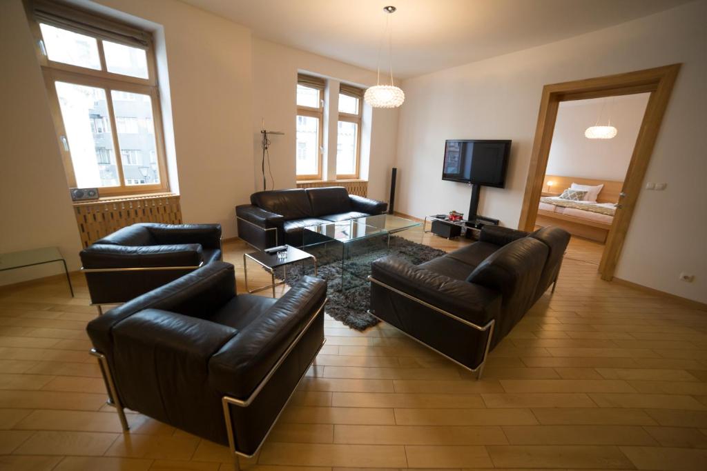 a living room with leather couches and a tv at President Apartment in Sarajevo