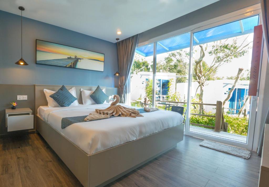 a bedroom with a large bed and a large window at Sara Resort in Koh Rong Sanloem
