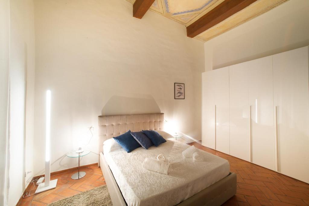 a bedroom with a large bed with blue pillows at Apo2 Deluxe 2bdr family apartment by Ponte Vecchio in Florence