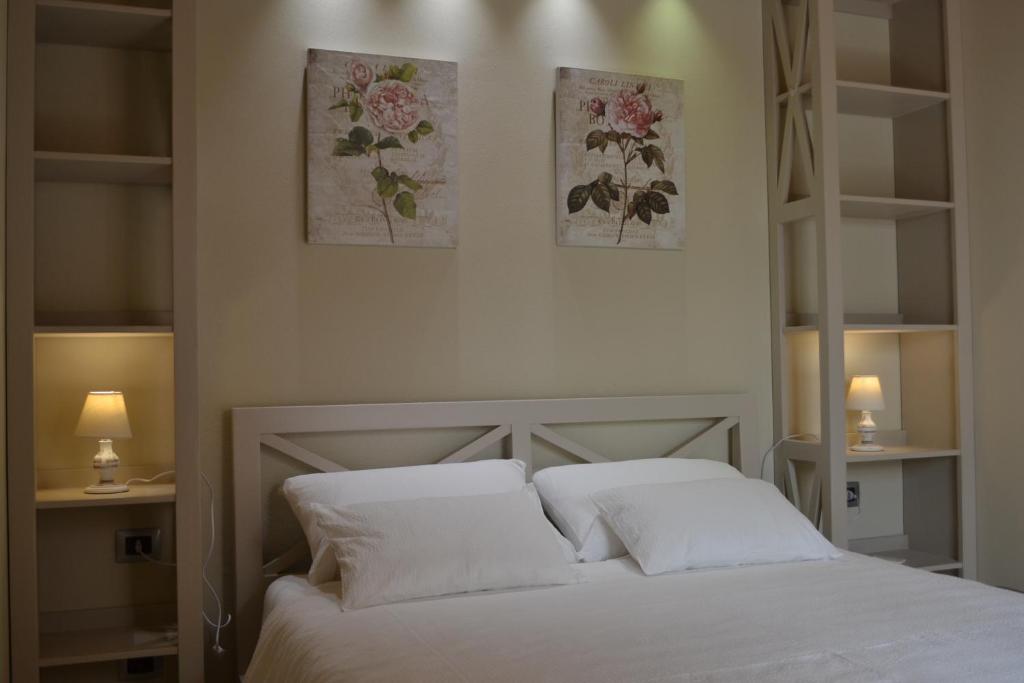 a bedroom with a white bed with two pillows at Hotel Danila in Portoferraio